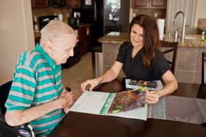 caregiver helping elderly man read